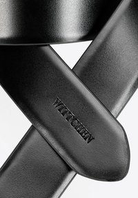 Ceinture en cuir noir avec une finition texturée, présentant une extrémité lisse et le logo "Wittchen" embossé, superposée en un motif croisé.