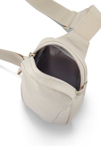 Borsa in tessuto beige con cerniera, dotata di una tracolla regolabile e di una fodera interna semplice. Nome del marchio "LARKSON" impresso sul fronte.