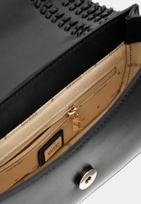 Borsa a mano in pelle nera con dettagli intrecciati, tasca interna con cerniera, fodera beige e etichetta del marchio. Presenti accenti in hardware dorato.