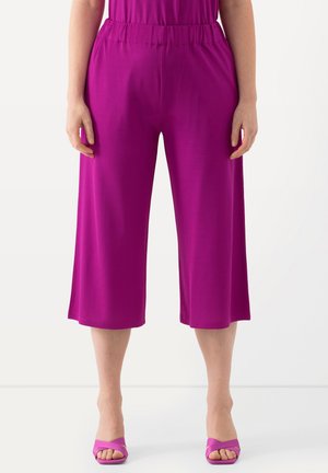 Magenta culotte-broeken met een elastische taille, met een gladde textuur en ruime pijpen, gecombineerd met bijpassende open-teen hakken.