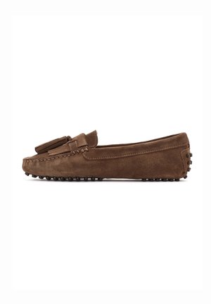 Mocassin en daim marron avec pompons, couture mocassin et semelle en caoutchouc à picots, vu de côté sur fond blanc.