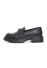 Mocassin en cuir noir avec semelle épaisse et détail de chaîne métallique sur le dessus, montrant le profil latéral extérieur.