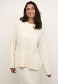 Crème kleurige oversized trui met een geribbelde onderrand en manchetten, gemaakt van een zachte, gestructureerde brei-stof, met een klassieke ronde halslijn.