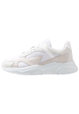 Baskets blanches et beiges avec dessus en mesh et daim, semelle épaisse et rembourrée, fermeture à lacets, vues de côté extérieur.