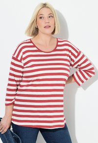 Rood-witte gestreepte overhemd met lange mouwen, een ronde halslijn en een relaxed fit, gecombineerd met donkerblauwe jeans. Glad, lichtgewicht stof.
