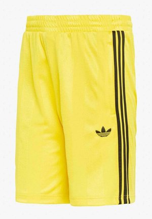 Pantalones cortos deportivos amarillos con cintura elástica, con detalle de tres rayas negras y el logo trefoil de Adidas en la pierna derecha.