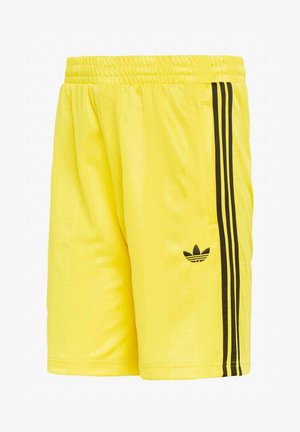 Pantalones cortos deportivos amarillos con cintura elástica, con detalle de tres rayas negras y el logo trefoil de Adidas en la pierna derecha.