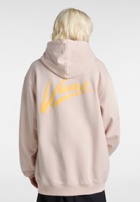 Hoodie rosa chiaro con un grande logo giallo "Vans" sulla schiena. Caratterizzato da un cappuccio con cordini e polsini e orlo a costine. Texture liscia.