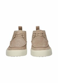 Para beżowych zamszowych butów typu lace-up, z białymi gumowymi podeszwami, widok z przodu, z uchwytami i logo "BLACKSTONE" na językach.