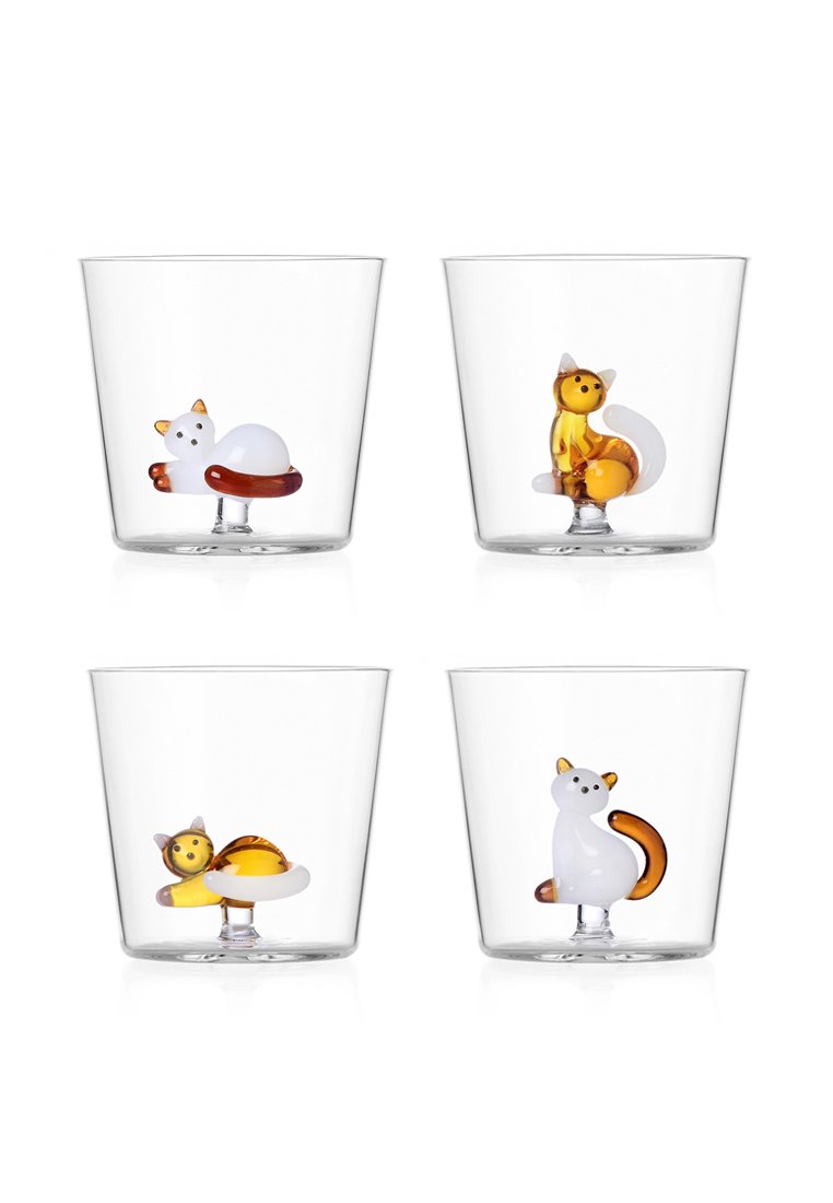 Cztery przezroczyste szklanki do picia, każda z małą, kolorową szklaną figurką kota w różnych siedzących i leżących pozach.