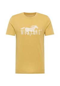 Camiseta de algodón amarilla con un gráfico blanco de un caballo galopante y la palabra "MUSTANG" en letras negritas debajo. Mangas cortas, cuello redondo.