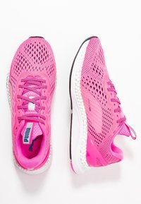 Scarpe da ginnastica rosa con tomaia in rete, superficie testurizzata, suola ammortizzata e logo in evidenza. Presentano lacci rotondi e accenti a contrasto.