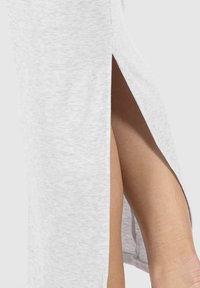 Hellgrauer, gerippter Stoffrock mit seitlichem Schlitz, der eine glatte Textur zeigt. Der Saum ist gerade und sauber verarbeitet.