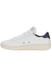 Vita lädersneakers med rund tå, beige gummisula och marinblå accent på hälen. Utrustad med snörning och små ventilationshål.