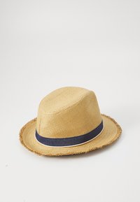 Sombrero de paja con ala desgastada, que presenta una banda de cinta en color navy con adornos en blanco. Color beige natural con textura tejida.