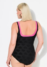 Zwarte badpak met een textuurpatroon van harten, roze bandjes, een scoop rugontwerp en een aansluitende pasvorm, die een soepele, elastische stof benadrukt.