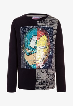 Camiseta negra de manga larga con gráfico de superhéroe de lentejuelas, que presenta un diseño dividido con patrones de tira cómica en un lado y lentejuelas coloridas.