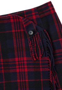 Teléfono de lana de cuadros en rojo y azul marino con cierre de botón, que presenta un detalle de flecos a lo largo del borde para aportar textura e interés visual.