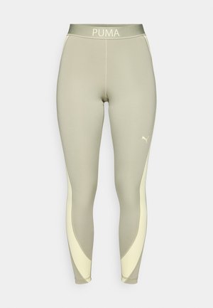 Leggings taille haute en vert clair et crème, avec une finition mate, des panneaux courbés, et le logo PUMA à la taille et à la cheville.
