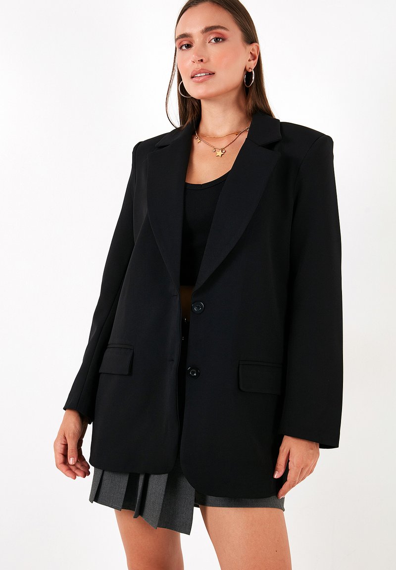 Blazer oversized negru, confecționat dintr-un material neted, având rever notate, două buzunare frontale și două butoane pentru închidere.