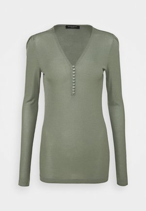Haut à manches longues en tricot côtelé de couleur vert olive doux, avec un col en V et des boutons sur le devant. Texture lisse et coupe ajustée.