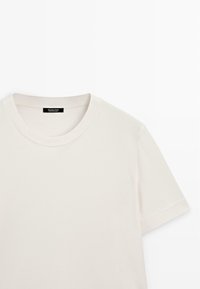 T-shirt bianco cremoso realizzato in morbido cotone. Vestibilità rilassata con scollatura rotonda e maniche corte. Design minimalista, senza motivi o accenti visibili.