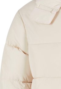 Puffjakke i lys beige med en glat, shiny overflade. Har en høj krave og en firkantet form med synlige sømme og polstring.