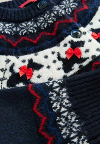 Navy knit sweater featuring white and red pattern with bows. Includes geometric designs and dog motifs. Soft texture with ribbed collar.