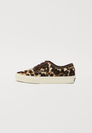 Zapatillas de lona con estampado de leopardo, cordones marrones, suela de goma blanca y acentos de costura. Presentan un diseño clásico de tipo bajo.