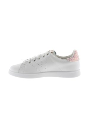 Sneaker bianca in pelle con dettagli perforati, punta tonda, suola piatta e un accento rosa testurizzato sul tallone. Lacci bianchi abbinati.