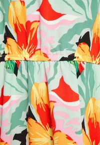 Tecido de vestido floral com grandes flores laranjas e vermelhas sobre um fundo verde claro, com detalhes em rosa e preto. Design texturizado e plissado.