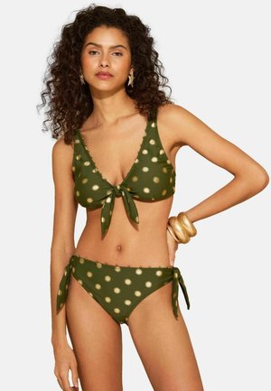 Olívazöld bikini szett, mely egy arany napmintás, elöl megkötős felsőből, hozzáillő oldalt megkötős alsóból és díszítő gyöngy részletekből áll.