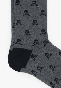 Calcetines grises con un patrón de calaveras y tibias en negro; refuerzo en las áreas del talón y los dedos, textura suave, de longitud hasta el tobillo.
