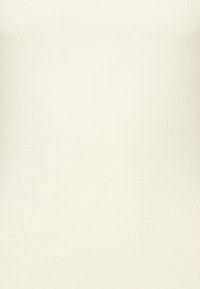 Ribbed, cream-colored fitted tank top made from stretchy fabric, featuring a smooth texture and seamless design.