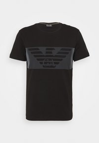 Svart bomullströja med horisontell mörkgrå rand, en örnlogotyp och texten "EA", rund halsringning och korta ärmar.