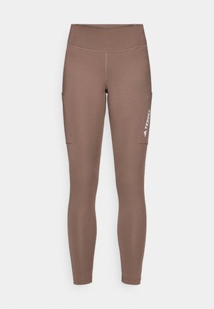 Brown athletic leggings with a high waistband, featuring side pockets and a white logo. Smooth, stretchy fabric for comfort and mobility.