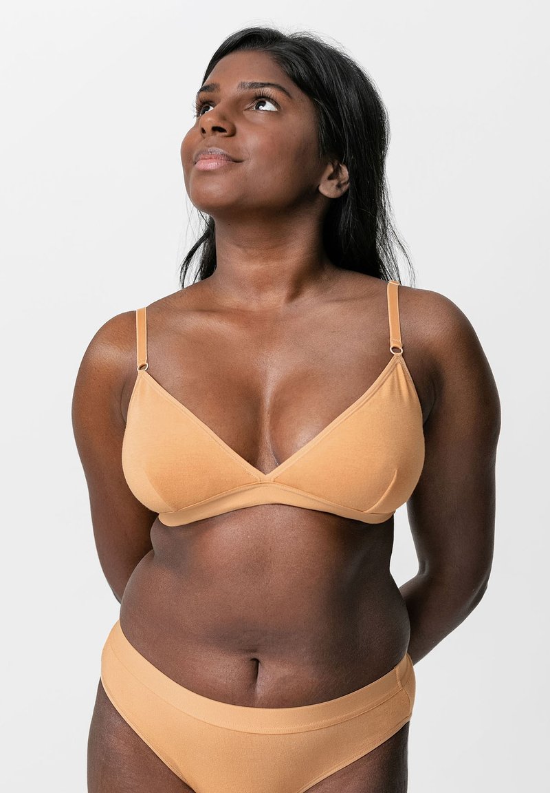 Driekhoek bralette en bijpassende slips van zacht tan stof, met dunne bandjes, naadloos ontwerp en een gladde, matte textuur.
