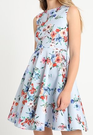 Ærmeløs lyseblå kjole med tætsiddende korsage og udvidet skørt, med et farverigt blomsterprint i røde, blå, pink og grønne nuancer.