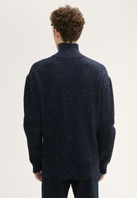 Navy gestrickter Pullover mit hohem Kragen, mit einem strukturierten Rippenmuster und gesprenkelten Akzenten, langen Ärmeln und lockerer Silhouette.