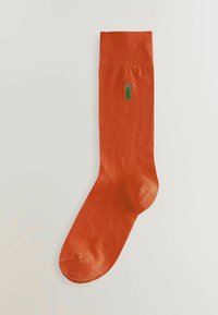 Orange bomuldsok med broderet grønt hummermotiv på den øverste del. Glat tekstur, standard sokform og -højde.