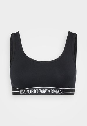 Melna kokvilnas bralette ar apaļu dekoltē, platām siksnām un biezu elastīgu jostu, uz kuras ir balta "Emporio Armani" logo.