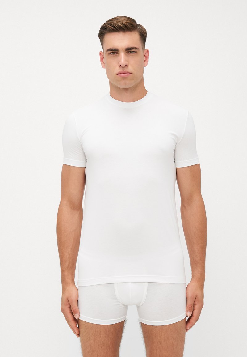 Weißes T-Shirt mit kurzen Ärmeln und Rundhalsausschnitt, aus glattem Stoff, taillierte Passform, kombiniert mit weißen Boxershorts.