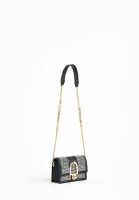 Borsa nera con parte anteriore borchiata, hardware dorato e tracolla a catena. Presenta un design strutturato e chiusura a doppio scomparto.