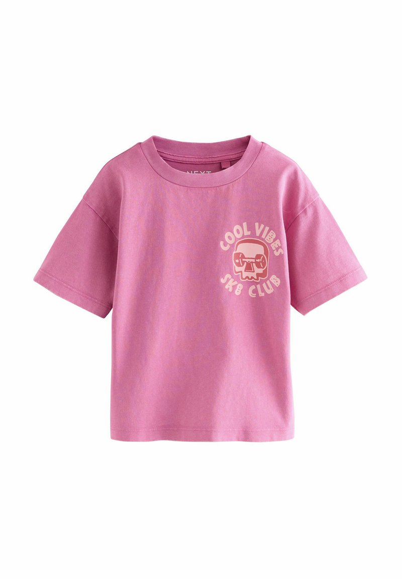 Rožinė medvilninė marškinėliai su trumpomis rankovėmis, ant kurių yra tekstas "COOL VIBES SK8 CLUB" ir grafika su kaukolės dizainu kairėje krūtinės pusėje.
