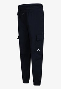 Schwarze Cargo-Hosen mit elastischem Bund, seitlichen Taschen, schmal zulaufendem Bein und einem weißen Jumpman-Logo auf der linken Seite.