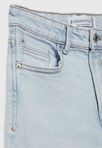 Jeans de mezclilla azul claro con cintura alta, diseño de cinco bolsillos, costuras en color cobre y etiqueta de marca en la cinturilla.
