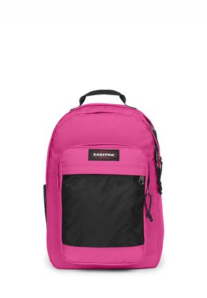 Lyserød rygsæk med sort frontnetlomme, sorte lynlåse og et sort håndtag øverst, med Eastpak-mærke foran.