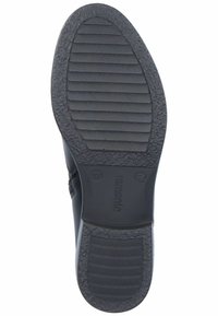 Schwarze Gummisohle mit horizontalen Rillen für besseren Grip, mit einer glatten, abgerundeten Kante und geprägten Größenangaben. Robuste Textur und Design.
