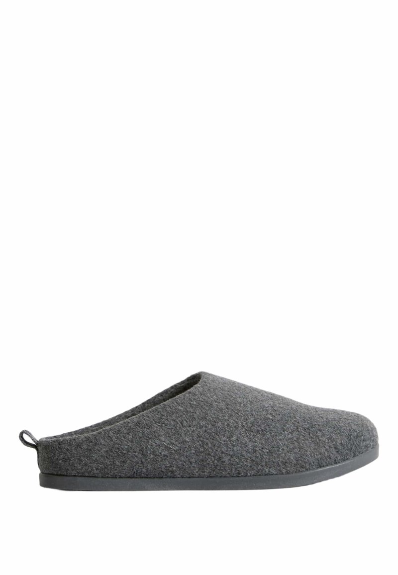 Pantufla gris de forma redondeada, con parte trasera abierta y superior texturizado. Cuenta con una suela de goma negra para agarre y durabilidad.