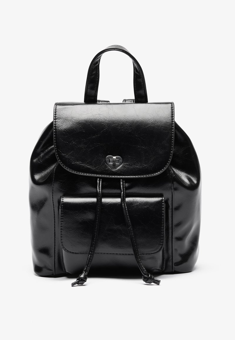 Black leather backpack with a front flap secured by a heart-shaped clasp and a front pocket, featuring two drawstrings and a top handle.